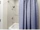 Updated bathroom features a combined shower and tub with blue shower curtain at 2075 Parkhaven Ct, Roswell, GA 30076