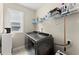 Well-lit laundry room features updated machines, shelving, and a window at 2075 Parkhaven Ct, Roswell, GA 30076