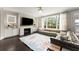 Bright living room with large windows, fireplace, and a plush, oversized sectional sofa at 2075 Parkhaven Ct, Roswell, GA 30076