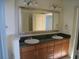 Bathroom featuring double sink vanity, granite countertops, and large framed mirror at 3445 Stratford Ne Rd # 2703, Atlanta, GA 30326
