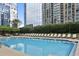 Sparkling pool surrounded by lounge chairs and lush landscaping with city views at 3445 Stratford Ne Rd # 2703, Atlanta, GA 30326