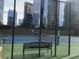 Outdoor tennis court with a bench and city view, enclosed by a chain-link fence at 3445 Stratford Ne Rd # 2703, Atlanta, GA 30326