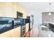 Close-up of a modern kitchen with stainless steel appliances, black countertops, and sleek wooden cabinets at 361 17Th Nw St # 1702, Atlanta, GA 30363