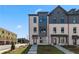 New townhouse exterior showcasing a modern design, light brick, and multiple windows under a blue sky at 433 Breccia Run, Mcdonough, GA 30253