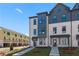 View of new townhouses showing the front exterior with grey accents, brickwork, and modern design under a bright sky at 433 Breccia Run, Mcdonough, GA 30253