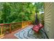 Relaxing outdoor deck featuring a swinging loveseat and a view of lush green trees at 1885 N Creek Cir, Alpharetta, GA 30009