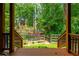 Scenic backyard view from the back deck showcasing mature trees, a creek, and a charming bridge at 1885 N Creek Cir, Alpharetta, GA 30009