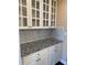 Butler's pantry with granite countertops, white cabinets, and glass fronts at 3381 Walkers Ridge Rd, Dacula, GA 30019