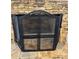 Fireplace with metal screen and brick surround at 3381 Walkers Ridge Rd, Dacula, GA 30019
