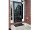 Elegant black front door with glass and side panels, framed by brick and a decorative welcome mat at 3381 Walkers Ridge Rd, Dacula, GA 30019
