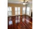 Bright living room with large windows, ceiling fan and gleaming hardwood floors at 3381 Walkers Ridge Rd, Dacula, GA 30019