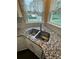 Close up of a stainless steel sink in the kitchen with granite countertops and white cabinets at 3381 Walkers Ridge Rd, Dacula, GA 30019