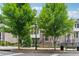 Attractive brick townhome featuring mature shade trees and a black metal gated entrance at 4012 Townsend Ln, Dunwoody, GA 30346