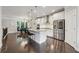 Open kitchen boasts stainless appliances, an island with seating, and hardwood floors next to the dining area at 4012 Townsend Ln, Dunwoody, GA 30346