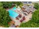 Aerial view showcases community pool, clubhouse, and lounge areas surrounded by mature trees at 5963 Wild River Vw, Sugar Hill, GA 30518