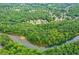 Aerial view of a community surrounded by lush greenery and a winding river at 5963 Wild River Vw, Sugar Hill, GA 30518