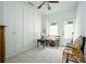 Bright bedroom featuring built-in wardrobes, a ceiling fan, and ample natural light with seating at 5963 Wild River Vw, Sugar Hill, GA 30518