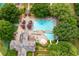 Aerial view of a community pool featuring multiple pool areas, lounge seating, and well-maintained landscaping at 5963 Wild River Vw, Sugar Hill, GA 30518
