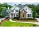 Charming two-story home with stone accents, a well-manicured lawn, and mature landscaping at 5963 Wild River Vw, Sugar Hill, GA 30518