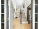 Inviting foyer with hardwood floors, staircase, and views into the living area with natural light at 5963 Wild River Vw, Sugar Hill, GA 30518