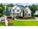 Charming two-story home with a manicured front yard, stone accents, blue shutters, and a side entry two-car garage at 5963 Wild River Vw, Sugar Hill, GA 30518