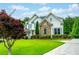 Beautiful two-story home with stone accents, white siding, blue shutters, and lush green lawn at 5963 Wild River Vw, Sugar Hill, GA 30518