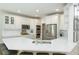 Well-lit kitchen featuring white cabinetry, quartz countertops and stainless appliances with an eat-in peninsula at 5963 Wild River Vw, Sugar Hill, GA 30518