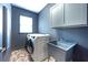 Modern laundry room with grey walls, stylish brick floors, and a washing machine at 5963 Wild River Vw, Sugar Hill, GA 30518