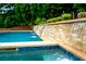 An in-ground pool featuring stone accents and waterfalls for a tranquil, resort-like outdoor space at 5963 Wild River Vw, Sugar Hill, GA 30518