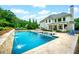 Backyard pool featuring in-pool loungers, waterfall feature, and seating area, perfect for outdoor relaxation and entertaining at 5963 Wild River Vw, Sugar Hill, GA 30518