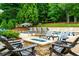 Backyard pool featuring a fire pit, lounge seating, and lush landscaping for relaxing or entertaining at 5963 Wild River Vw, Sugar Hill, GA 30518