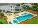 An aerial view of a backyard featuring a sparkling pool, tanning deck, outdoor seating, and fire pit at 5963 Wild River Vw, Sugar Hill, GA 30518