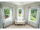 Bright sitting area with a bench seat surrounded by windows overlooking the backyard pool at 5963 Wild River Vw, Sugar Hill, GA 30518
