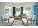 Cozy sitting area with matching armchairs, bench seating, and ample natural light through large windows at 5963 Wild River Vw, Sugar Hill, GA 30518