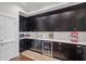A kitchenette with dark cabinetry, white countertops, a wine fridge and stainless steel appliances at 629 2Nd Avenue, Decatur, GA 30030