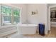 Bright bathroom features a standalone soaking tub, next to a window, and a walk-in closet at 629 2Nd Avenue, Decatur, GA 30030