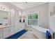 Spa-like bathroom showcasing a freestanding tub, double sink vanity, modern fixtures, and a picture window at 629 2Nd Avenue, Decatur, GA 30030