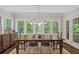 Sunlit dining room features a large wood table and multiple windows with lush green views at 629 2Nd Avenue, Decatur, GA 30030