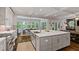 Bright, open-concept kitchen with a large island, stainless steel sink, white cabinets, and connection to dining area at 629 2Nd Avenue, Decatur, GA 30030