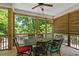 Relaxing screened porch with outdoor dining table, wooden floors, and views of the green surrounding trees at 629 2Nd Avenue, Decatur, GA 30030