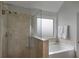 Bathroom featuring a glass shower, soaking tub and window at 909 Shatley Dr, Stockbridge, GA 30281