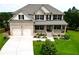 Charming two-story brick home boasts a manicured lawn, two-car garage, and inviting front porch at 909 Shatley Dr, Stockbridge, GA 30281