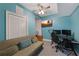 A blue painted home office space with a futon and computer desk underneath a ceiling fan at 909 Shatley Dr, Stockbridge, GA 30281