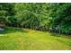 Expansive backyard with lush green lawn and mature trees, offering ample space and privacy at 1010 Longcreek Pointe, Alpharetta, GA 30005