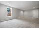 View of a basement area with new carpet, neutral paint, bright windows, and a door at 1010 Longcreek Pointe, Alpharetta, GA 30005