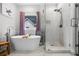 Bright bathroom featuring a modern tub, separate glass shower, and white tiled walls at 1010 Longcreek Pointe, Alpharetta, GA 30005