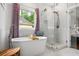 Bright bathroom featuring a modern tub, separate glass shower, and white tiled walls at 1010 Longcreek Pointe, Alpharetta, GA 30005