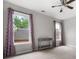 A bedroom features neutral walls, and two windows adorned with patterned curtains at 1010 Longcreek Pointe, Alpharetta, GA 30005