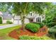 Well-manicured front lawn with mulched beds, and a lovely stucco home with two-car garage at 1010 Longcreek Pointe, Alpharetta, GA 30005