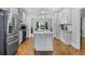 Spacious kitchen with island, white cabinets, stainless steel appliances, and hardwood floors at 1010 Longcreek Pointe, Alpharetta, GA 30005